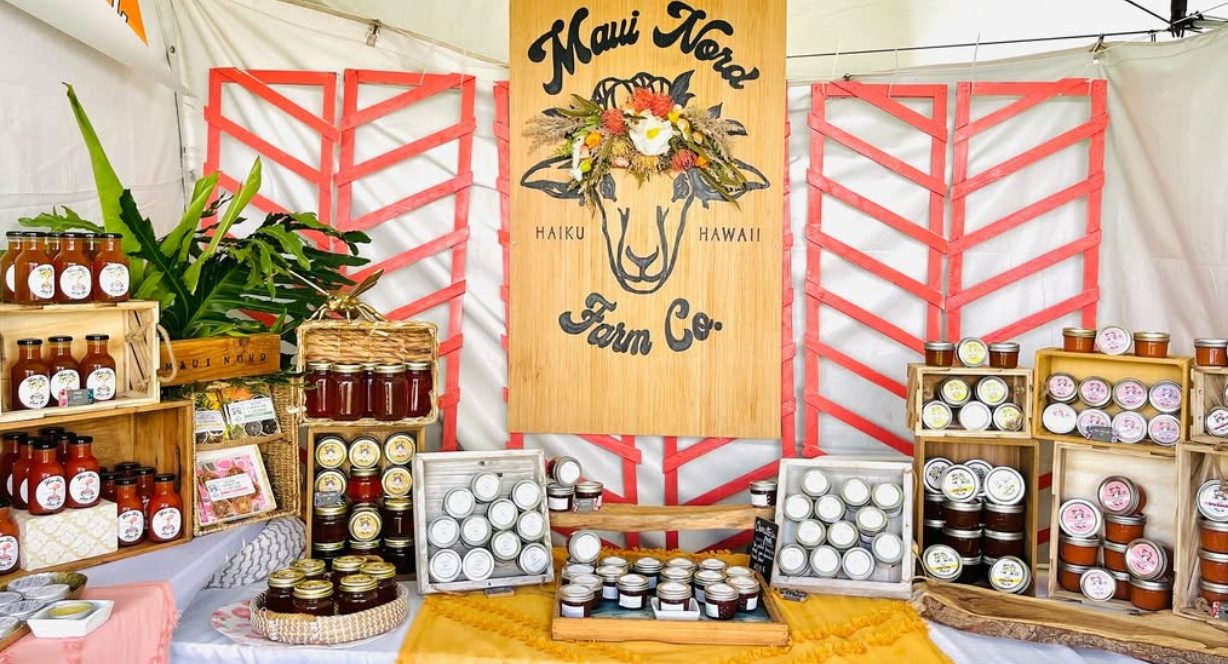 The market booth: the wooden sheep sign, jars on both sides, a yellow cloth