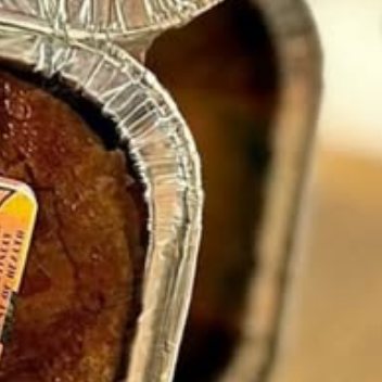 The crust of a guava bread loaf in its foil pan