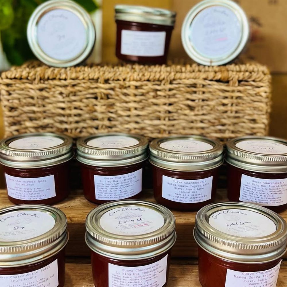 Jars of guava charcuterie paste stacked in front of a basket
